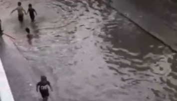 İzmir’de göle dönen sokakta çocuklar yüzdü